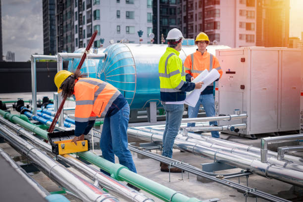 istock engineer under checking the industry cooling tower air conditioner is water cooling tower air chiller HVAC of large industrial building to control air system. 1422089629