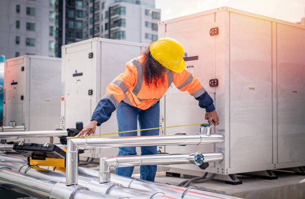 istock engineer under checking the industry cooling tower air conditioner is water cooling tower air chiller HVAC of large industrial building to control air system. 1422089637