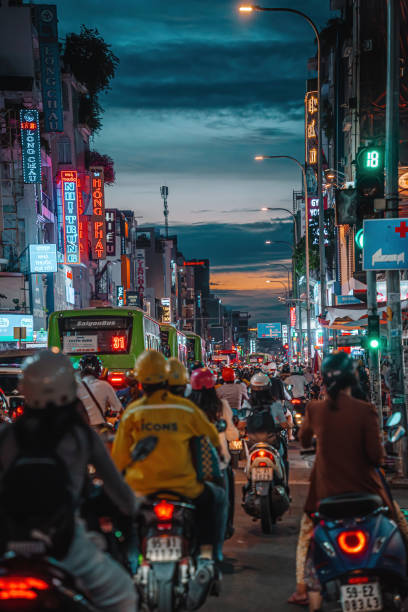 ora di punta, ingorgo affollato durante il tramonto e prospettiva colorata di hai ba trung st con numerose insegne di hotel, bar e negozi, affollato di persone, moto - slow moving vehicle sign foto e immagini stock