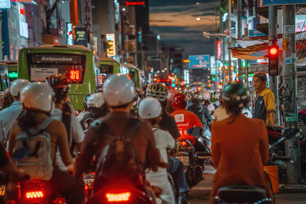 ora di punta, ingorgo affollato durante il tramonto e prospettiva colorata di hai ba trung st con numerose insegne di hotel, bar e negozi, affollato di persone, moto - slow moving vehicle sign foto e immagini stock