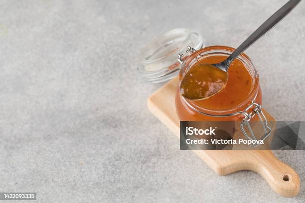 Glass Jar With Fruity Orange Jam On A Grey Background Fruit Preservation Stock Photo - Download Image Now