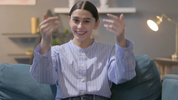 istock Hispanic Woman Inviting while Sitting at Home 1422095042