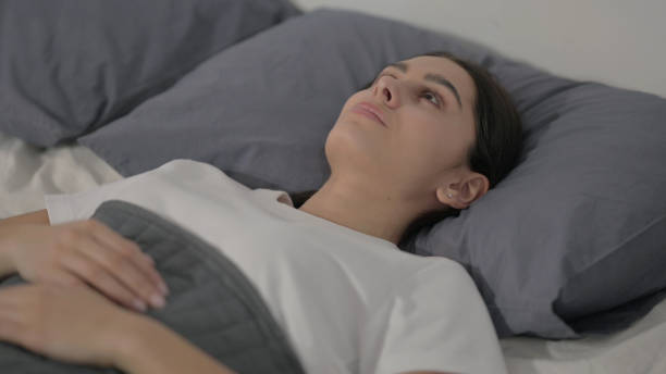 istock Hispanic Woman Awake in Bed Thinking 1422097357