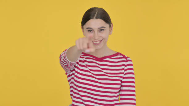 istock Spanish Woman Pointing at the Camera on Yellow Background 1422102246