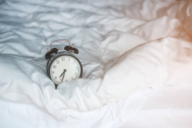 istock Vintage alarm clock on bed and copy space for text. Wake up, sleeping, daily routine, morning, workout and Work life balance concept 1422103749