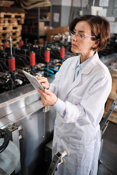istock Female executive working with tablet, checking factory machines 1422108176