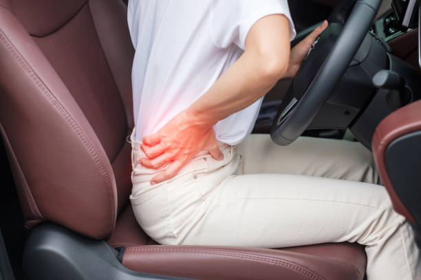 istock woman with her back sprain while driving car long time, back body ache due to Piriformis Syndrome, Low Back Pain and Spinal Compression. Ergonomic and medical concept 1422110868
