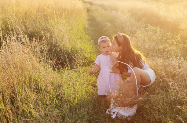 istock two little sisters in summer field at sunset 1422111973