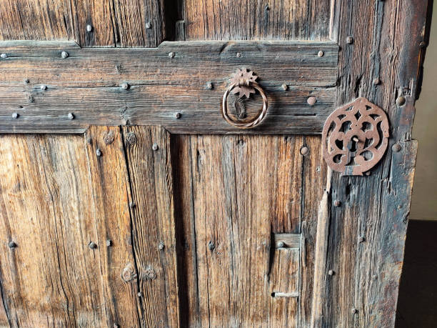 historic iron door fittings on a weathered medieval wooden door stock photo