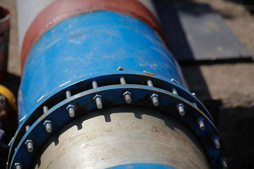 Shallow depth of field (selective focus) details with a metallic pipeline for hot water.