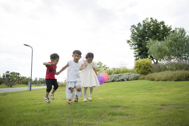 istock Asian kids playing with balloons in the grass 1422115424