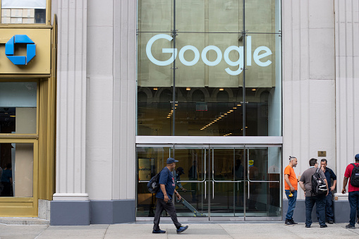 New York, NY, USA - July 7, 2022: A man walks past the Google office, the Chelsea campus, in New York City. Google LLC is a global technology company headquartered in Mountain View, California.