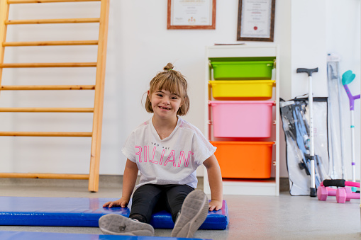 portrait of girl with down syndrome at physical therapy