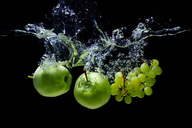 istock Apples and grapes dropped in water with splashes 1422121590