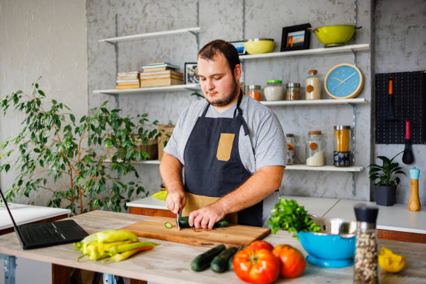 istock Overweight man chopping vegetables 1422122268