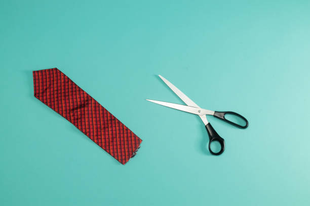 istock Neckties being cut by a large black scissors. 1422124056