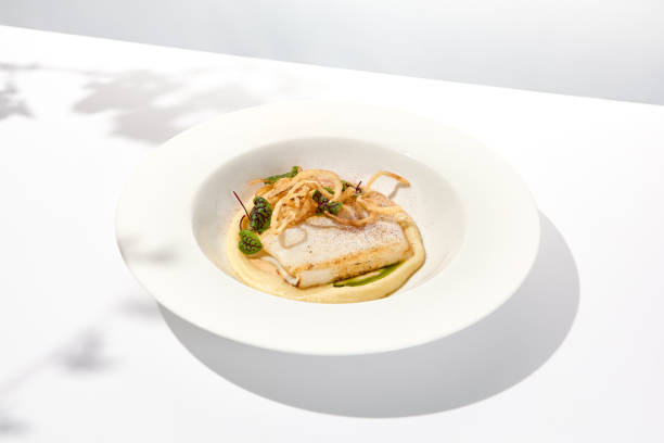 istock Roasted squid on mashed potatoes and crispy onion. Grilled squid with celery cream on white plate with shadows of leaves. Summer seafood menu. Roasted calamari in fine dining. 1422127825
