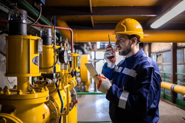 trabajador industrial profesional que verifica la presión de la tubería de gas natural dentro de la planta de energía o refinería. - boiler power station fuel and power generation gas boiler fotografías e imágenes de stock