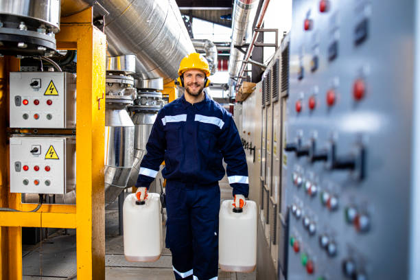 istock Refinery worker carrying plastic canisters for chemicals. 1422137786
