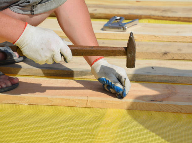istock Roofer contractor nailing wooden timber during house roofing construction. 1422138919