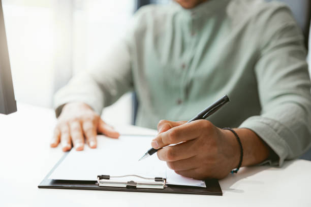 istock Close up of businessman working with documents while sitting in office 1422140019