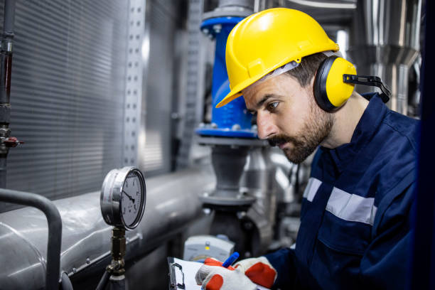 caucasian worker controlling pressure and heat in pipes of heating plant. - boiler power station fuel and power generation gas boiler imagens e fotografias de stock