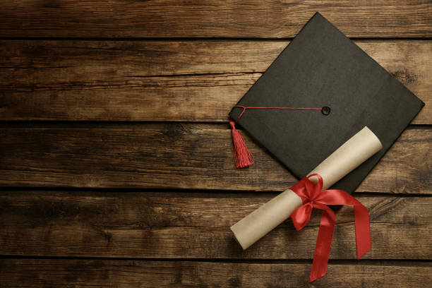 istock Graduation hat and diploma on wooden table, flat lay. Space for text 1422142020