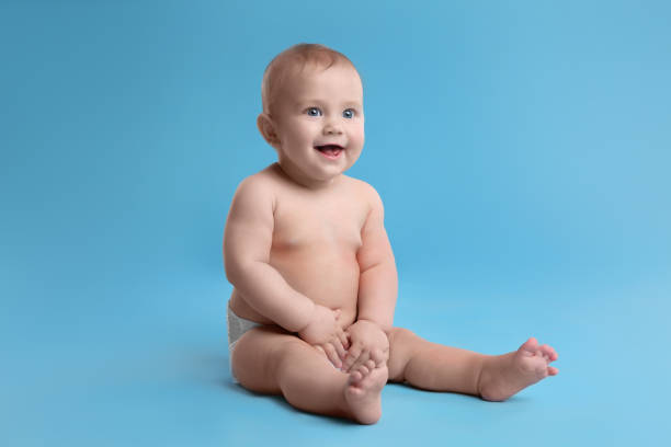 istock Cute baby in dry soft diaper sitting on light blue background 1422142115