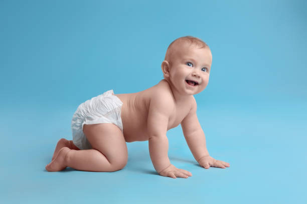 istock Cute baby in dry soft diaper crawling on light blue background 1422142167