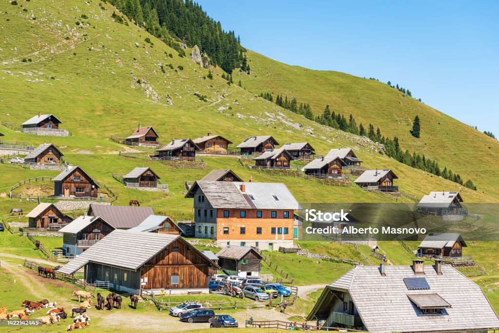 Small Village in the Carnic Alps - Italy-Austria Border Carinthia Small village in the Carnic Alps with herd of dairy cows and horses. Mountain peak of Osternig or Oisternig, Italy-Austria Border. Feistritz an der Gail municipality, Carinthia, Austria, central Europe Austria Stock Photo