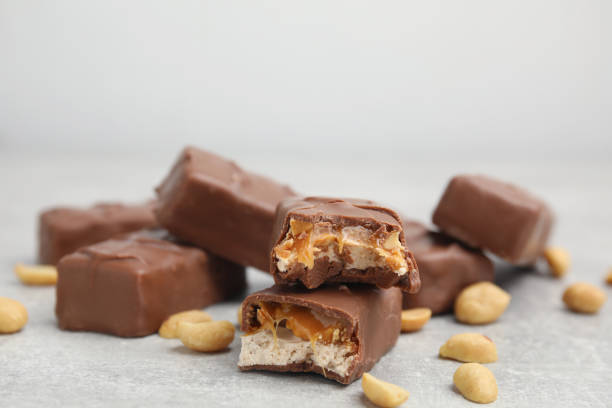 istock Chocolate bars with caramel, nuts and nougat on light grey table, closeup 1422142463