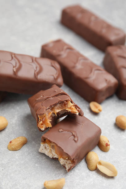 istock Chocolate bars with caramel, nuts and nougat on light grey table 1422142531