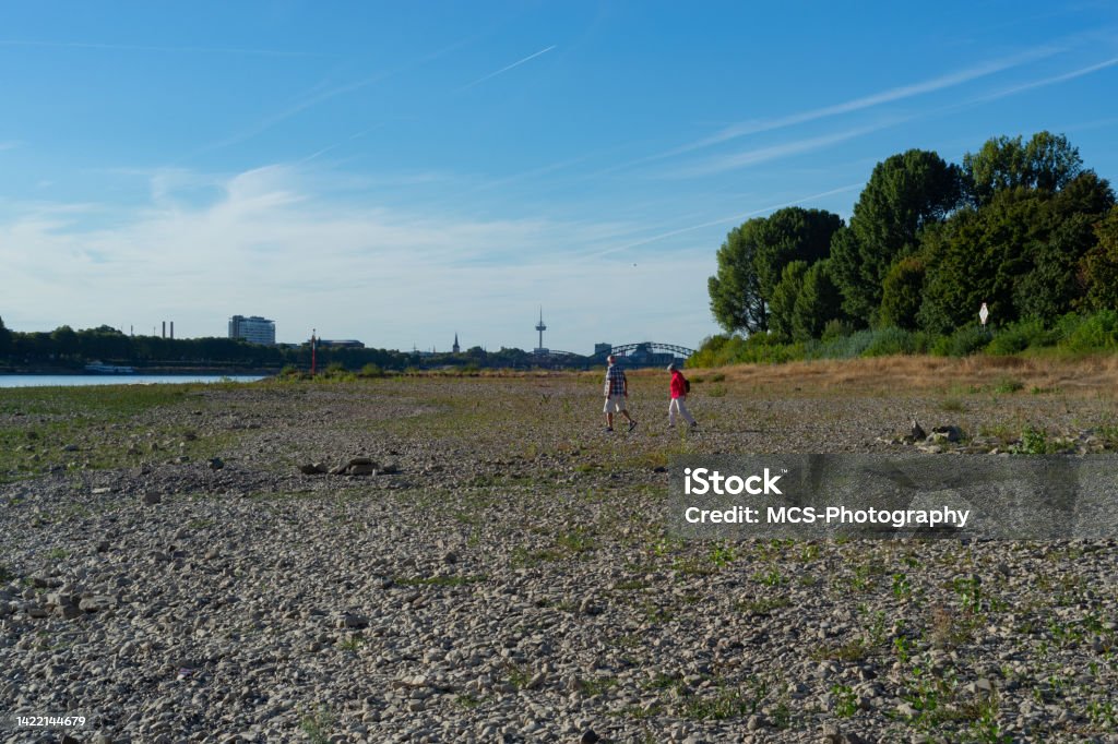 Bank of Rhein river in Cologne Senior couple strolling the right bank of Rhein river in Cologne - Poll at extremely low water level Cologne Stock Photo