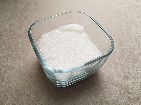 Granulated sugar in a glass bowl on the table