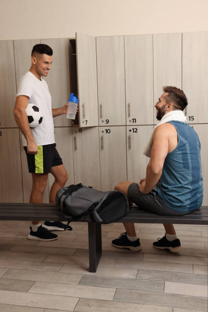 istock Handsome athletic men talking in locker room 1422157505