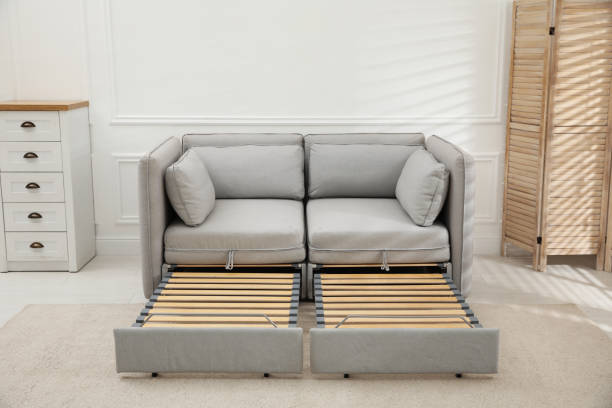 istock Stylish room interior with sleeper sofa near white wall. Additional place for guest 1422162953