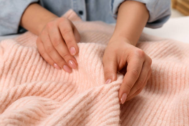istock Woman touching soft pink knitted fabric, closeup 1422165459