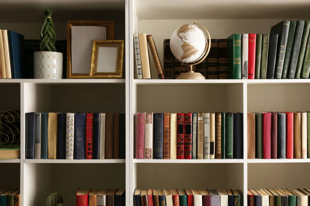 istock Collection of books and decor elements on shelves. Home library 1422165692