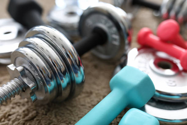 istock Pile of shiny chrome dumbbells disks lying around grip 1422166152