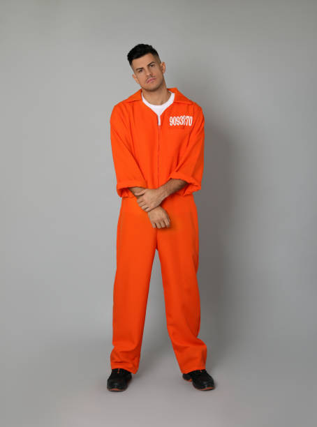 istock Prisoner in orange jumpsuit on grey background 1422167201