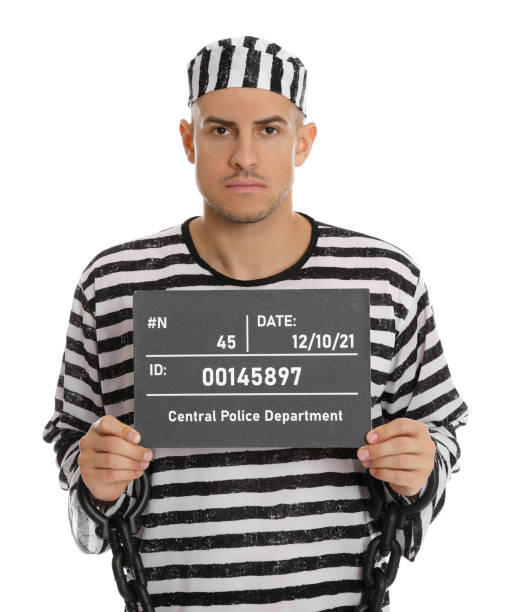 istock Mug shot of prisoner in striped uniform with board on white background, front view 1422167304