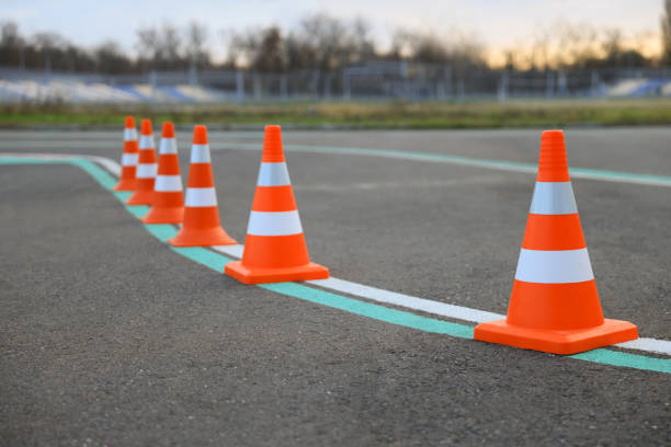 istock Driving school test track with marking lines, focus on traffic cone 1422168168