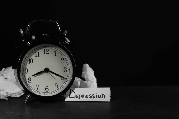 istock Depression sign, alarm clock and used tissues on black table against dark background, space for text 1422168609