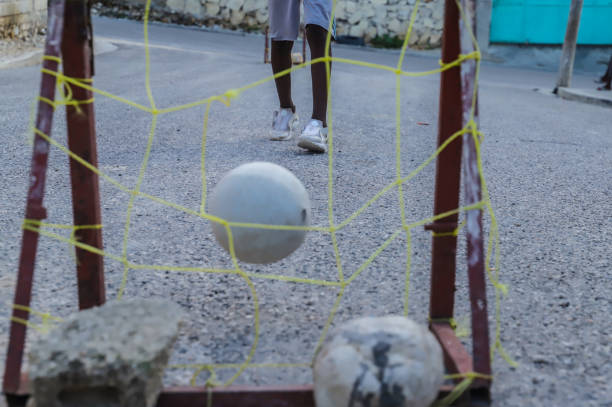 Three quarter front view of cute young boy soccer goalie ready to throw soccer ball to his teammates.