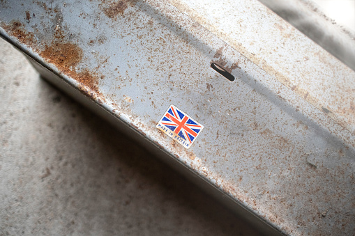 Well used, weathered rusty metal toolbox with an old 'Made in Britain' sticker on.