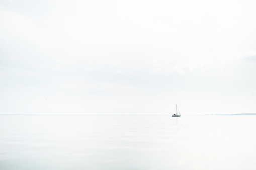 Sailboat on empty lake on a morning with no wind, Mecklenburg-Vorpommern