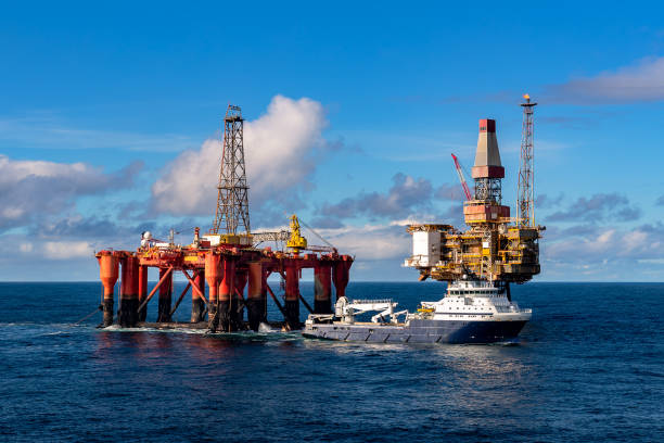 AHTS vessel Island Valiant doing rig move operation for semi submersible rig Borgsten Dolphin next to Dunbar platform NORTH SEA, UK - 2016 OCTOBER 01. AHTS vessel Island Valiant doing rig move operation for semi submersible rig Borgsten Dolphin next to Dunbar platform north sea oil and gas stock pictures, royalty-free photos & images