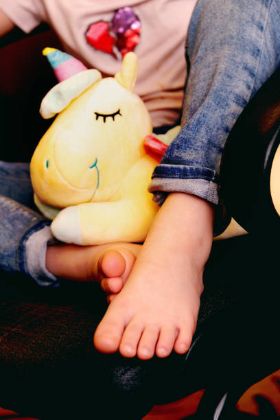 Blurred close up  barefoot,  funny freind toy,  relaxing at home, authentic scene