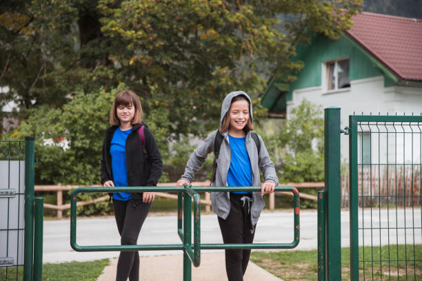 A child girl with blond hair in a pink T-shirt sits offended and sad on the playground.