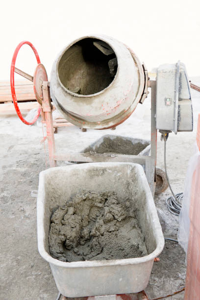 Cement mixer and cement vat Cement mixer and cement vat filled with cement, on a construction site of a new family home. This image is part of a series. mixing vat stock pictures, royalty-free photos & images